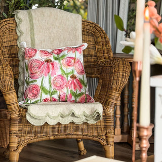 Floral pillow on a wicker chair with a candle in the background. European Cottage Steal It Box