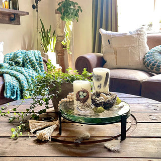 Decorative glass stand with candles and bird nest