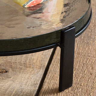 Glass riser with lit candles and nest décor