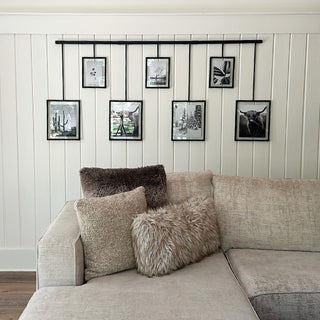 Hanging gallery frames above sectional sofa