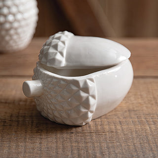 White porcelain acorn container with lid partially open