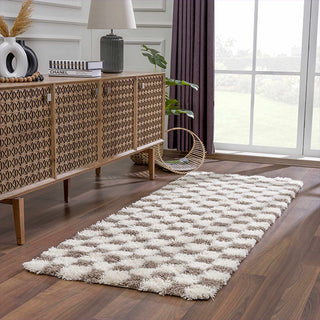 Living room with a patterned rug, wooden sideboard, and large window.