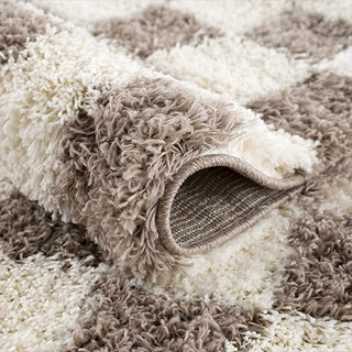 Close-up of a textured beige and white rug with a rolled edge.