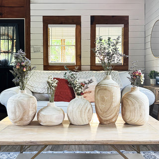 Collection of rustic wooden vases with dried flowers