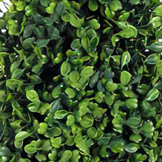 Close-up detail of realistic faux boxwood leaves on artificial topiary tree