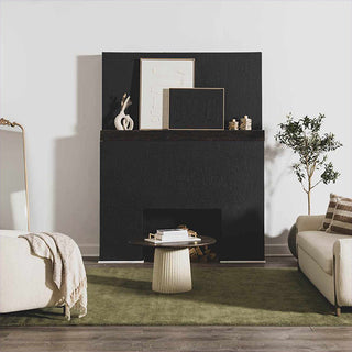 Modern living room with a black fireplace, white sofa, and green rug.