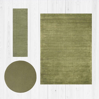 Three green rugs of different shapes on a white wooden floor.