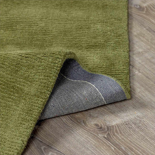 Green textured rug on a wooden floor