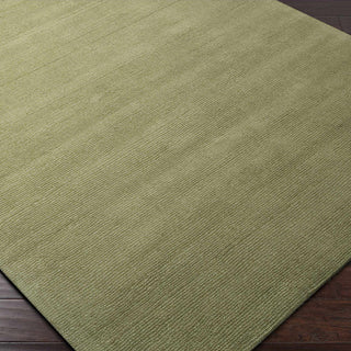 Green rug on a wooden floor