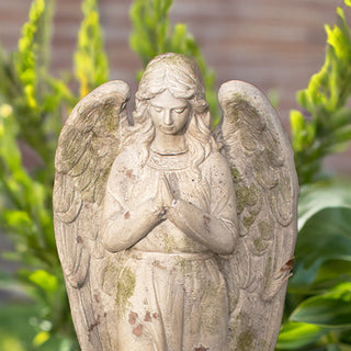 Detailed view of distressed resin angel statue with praying hands, rustic garden décor piece