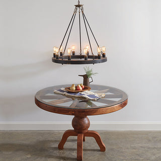 Rustic round chandelier above wood dining table
