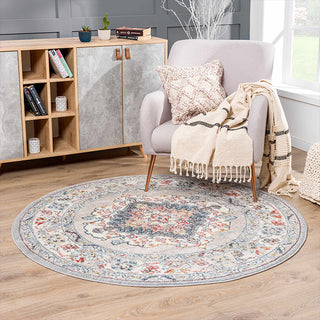 Round floral rug in a living room with a chair, books, and a cabinet.