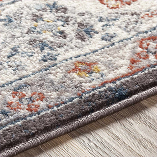 Close-up of a patterned rug with multicolor design on a wooden floor.