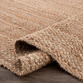 Close-up of a textured natural beige jute rug on a wooden floor