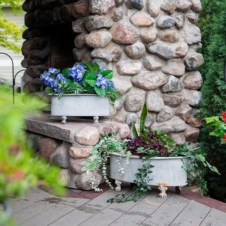 Two galvanized metal planters styled with hydrangeas and greenery on patio