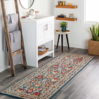 Bathroom with a decorative rug on the floor, wooden ladder with towels, and white vanity.