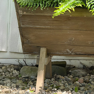 Close-up view of the lower corner of a distressed reclaimed-wood planter box