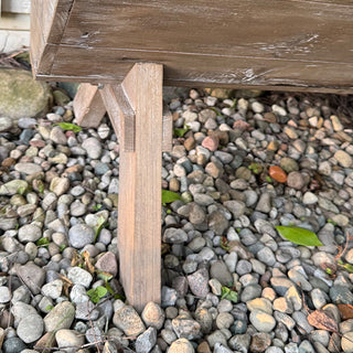 Detail shot of the wooden leg and base of a rustic reclaimed-wood planter box