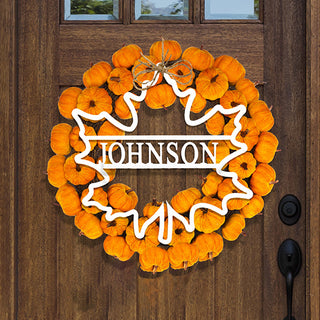Personalized maple leaf door sign with “Johnson” name, styled on pumpkin wreath for fall decor