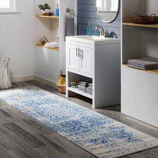Bathroom with a blue and white patterned rug on the floor.