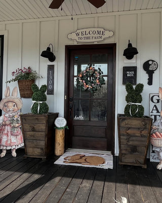bunny sign with bunny topiaries in wood planters easter decor and spring decor on front porch