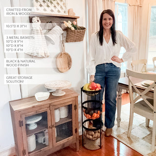 Woman standing next to a three-tier black metal fruit storage rack in a farmhouse-style kitchen with size and material details displayed.