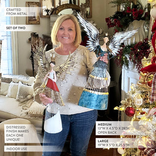 Woman holding set of two metal angel decorations showing size comparison, medium and large angels with open back design