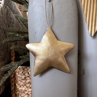 Gold star ornament detail hanging from distressed metal angel figurine Christmas decoration