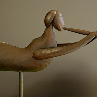 Detailed view of rustic distressed metal angel figurine holding a trumpet, farmhouse-style Christmas decoration