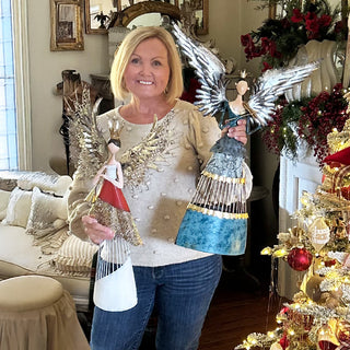 Full set of two metal angel decorations held by model showing craftsmanship and size variations