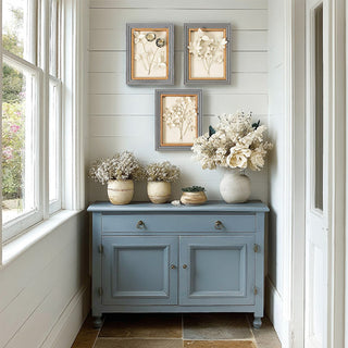 Blue accent cabinet with framed floral wall art decor