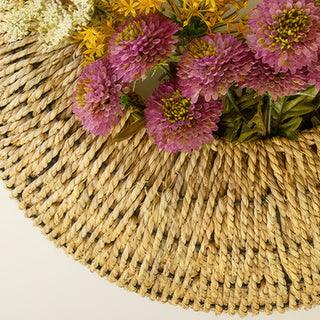 Close-up woven seagrass basket with faux flowers