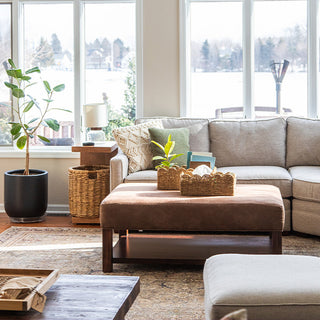 Scalloped seagrass basket holding toilet paper rolls on bathroom toilet tank