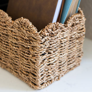 Handwoven seagrass storage basket on nightstand in cozy bedroom setting