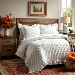 Cozy bedroom with white ruffle quilt and pillow shams