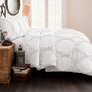 White ruffled bedding set styled in modern bedroom with blush headboard and plantation shutters