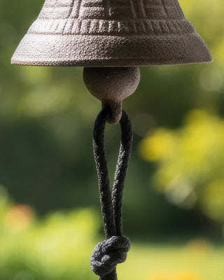 Wall-mounted bird bell on farmhouse entryway exterior