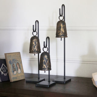 Rustic iron bells on black metal stands