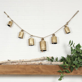  Farmhouse bell garland styled on white brick fireplace mantel with greenery