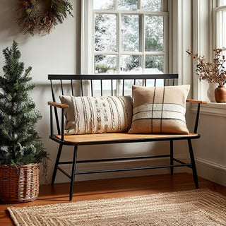 Modern farmhouse bamboo bench with black metal spindle back in cozy entryway next to Christmas tree and beige armchair