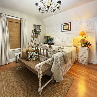 Cozy bedroom with wooden bench, bed, and decorative elements.