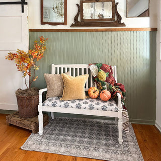 Farmhouse bench styled with fall pillows and pumpkins