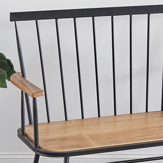 Close-up detail of bamboo wood armrest and black metal spindle back construction on farmhouse entryway bench