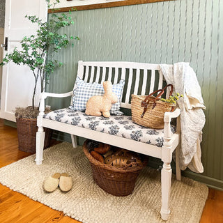 White entryway bench with basket and throw blanket