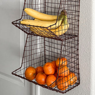 Bananas and oranges in rustic wire wall basket