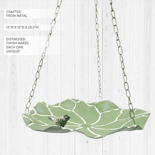  Metal platform bird feeder in garden setting with flowering plants
