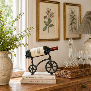 Cast iron bicycle wine bottle holder with spoked wheels on kitchen counter
