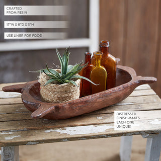 Decorative resin dough bowl with bottles and plant