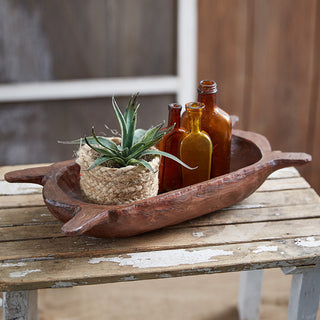Farmhouse dough bowl with amber bottles and plant