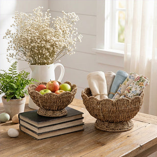 Natural seagrass woven pedestal bowls set of 2 displaying fresh fruit and rolled towels on wooden console table